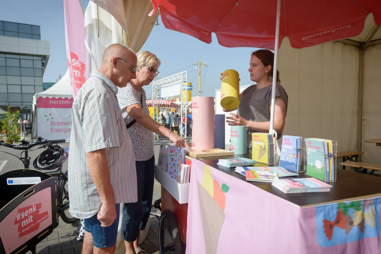 &Auml;lteres Ehepaar steht vor Stand, Frau ber&auml;t